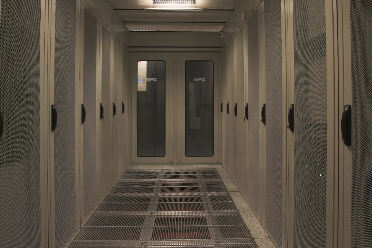 Datacenter ZPAS – couloir avec rangées de baies serveurs perforées