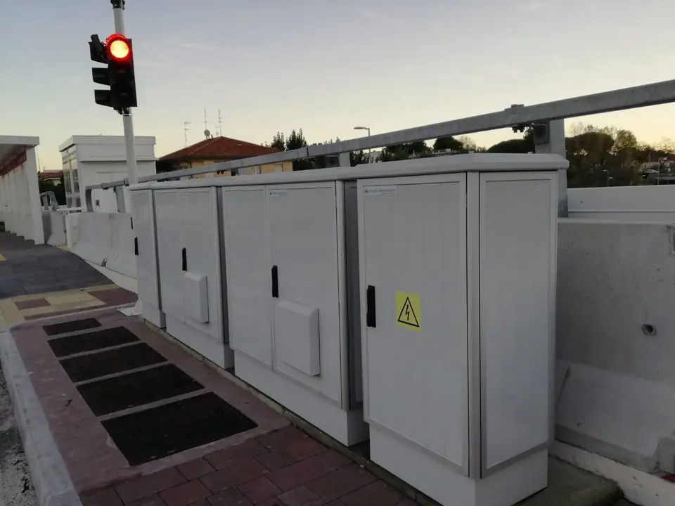 Row of cabinets at the concrete safety barrier, view along the doors