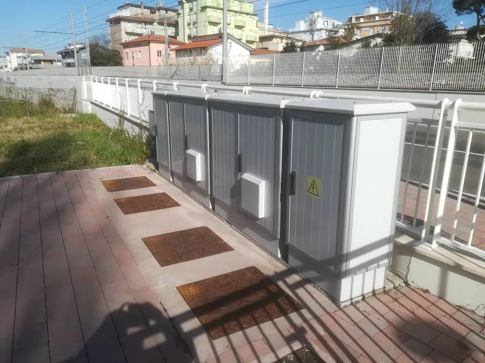 Row of cabinets along a railing, warning sign on the door