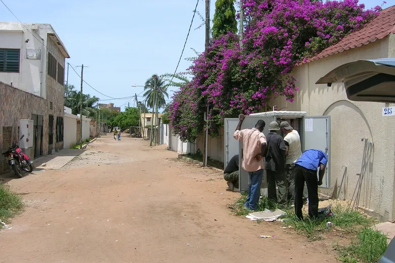 Techniker arbeiten an einem geöffneten ZPAS Outdoorschrank in einer Straße in Togo