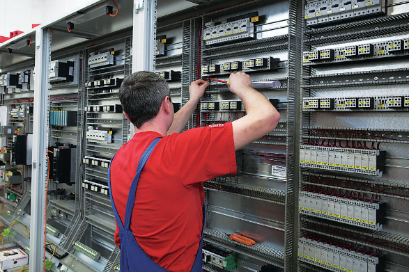 ZPAS Elektriker bei der Verdrahtung eines Schaltschranks – Reihenklemmen und Kabelführung in der Werkstatt