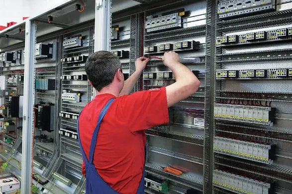 Électricien ZPAS câblant une armoire électrique sur des borniers